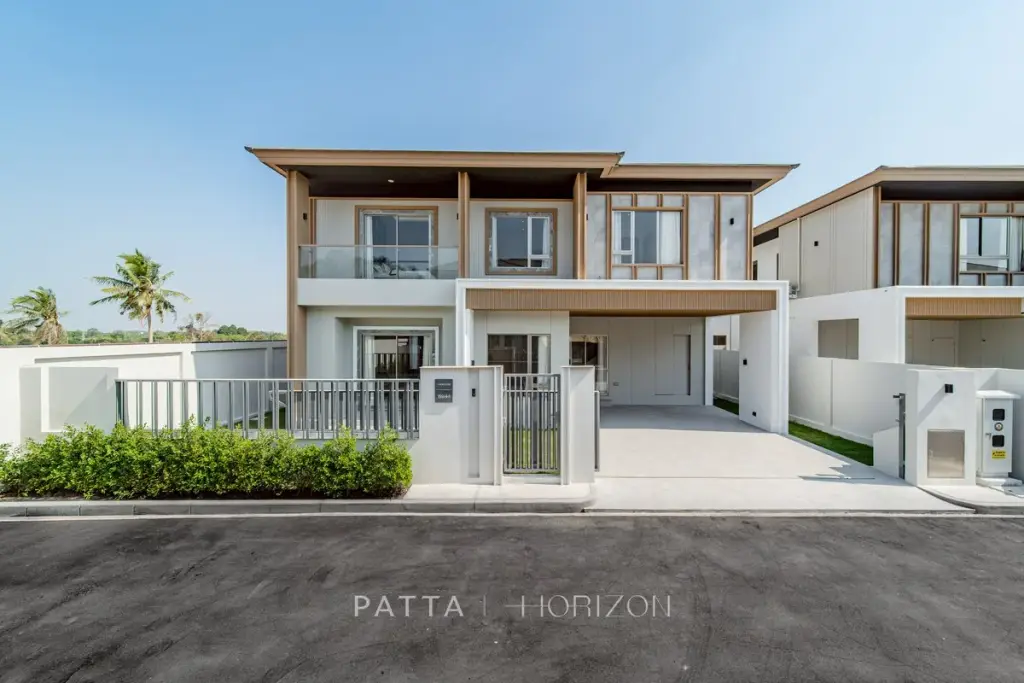 Horizon By Patta main entrance building with a modern design, cars, and lush green landscaping under a clear sky.