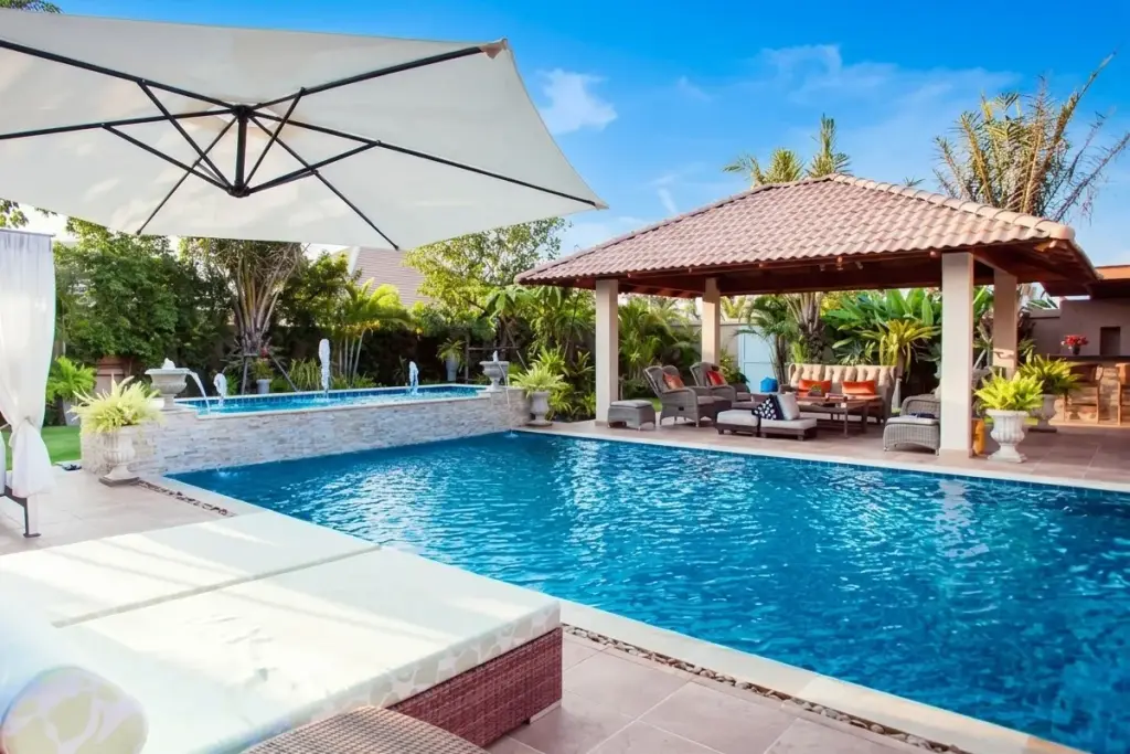 Sedona Villas 1 luxurious outdoor swimming pool with sun loungers, patio umbrella, and covered lounge area with seating.