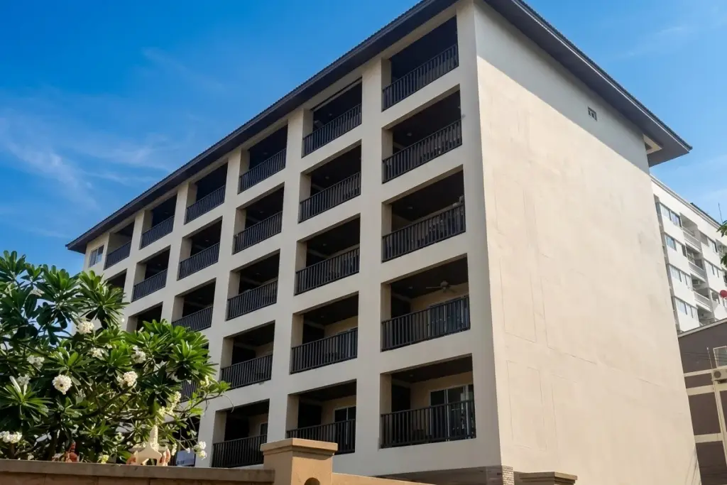 Katalina Residence exterior, showing multiple floors of balconies with dark railings, light facade, and a low wall.