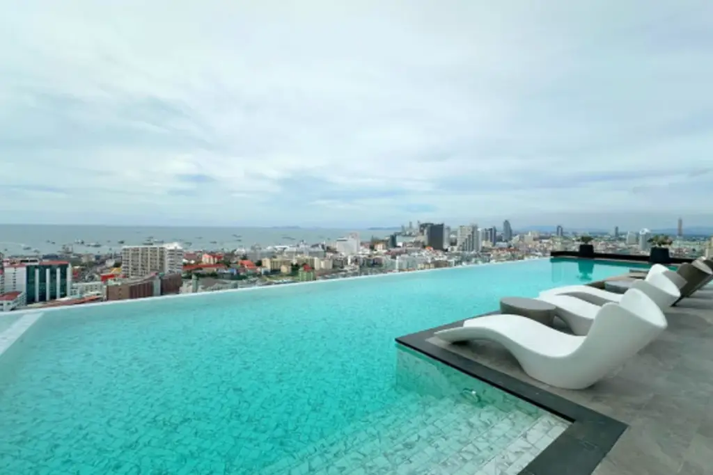 2 Bedroom Condo for Sale at Arcadia Millennium Tower living room with white sofa and dining table by window