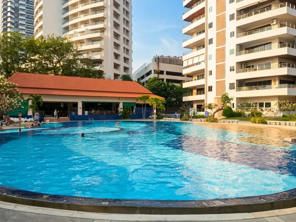 View Talay 3A large circular outdoor pool with swimmers and poolside clubhouse building