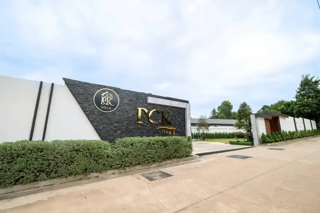 PCK Villa branded entrance gate with black stone signage, trimmed hedges and gated driveway in Pattaya