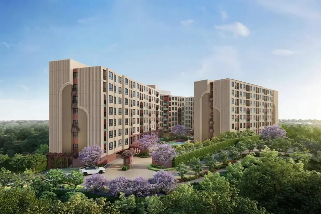 D Condo Vite aerial exterior view of multi-storey condo buildings with arched facades surrounded by purple flowering trees in Pattaya