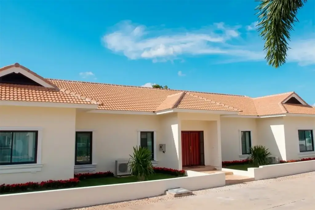Maprachan 1 single-story condo exterior with cream walls, terracotta roof, red double door, and landscaped garden.