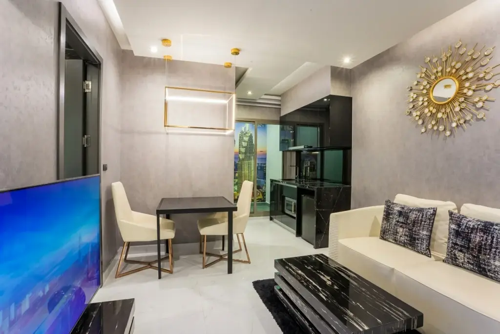 1 Bedroom Condo for Sale at Grand Solaire Pattaya living and dining area with sunburst mirror and city view window