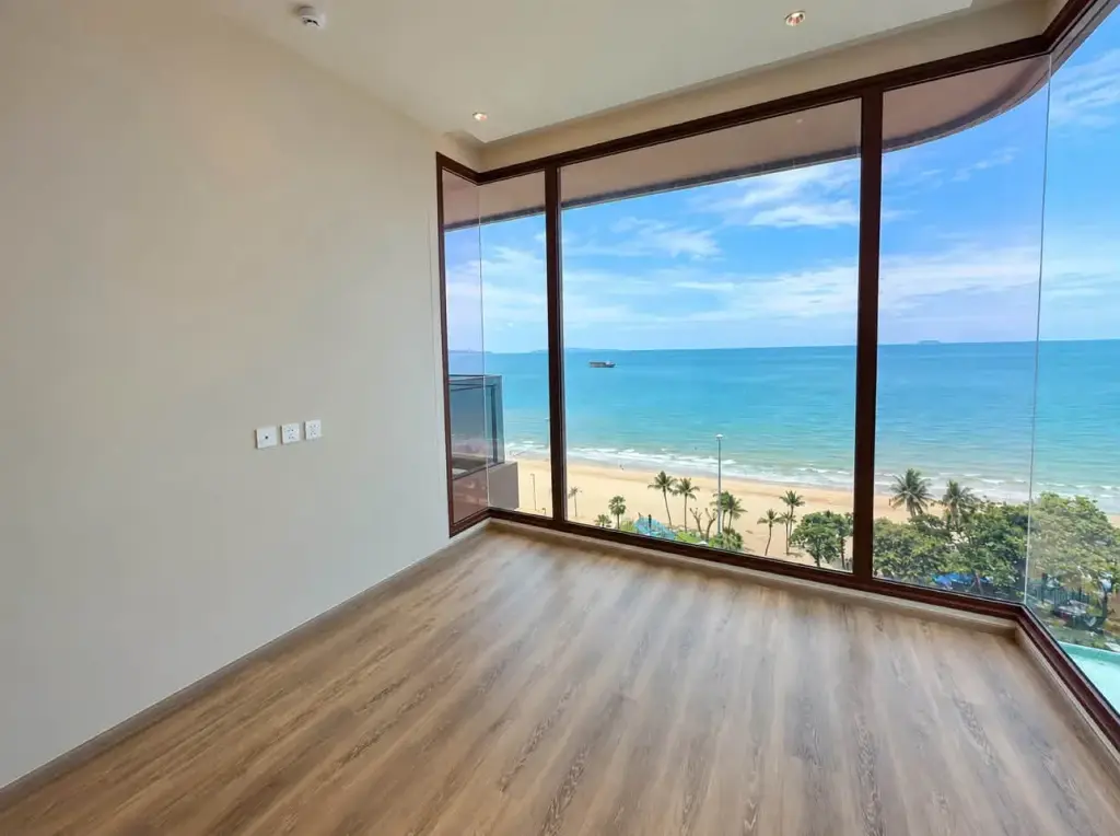 2 Bedroom Condo for Sale at Arom Jomtien empty bedroom with floor-to-ceiling windows overlooking beach and sea