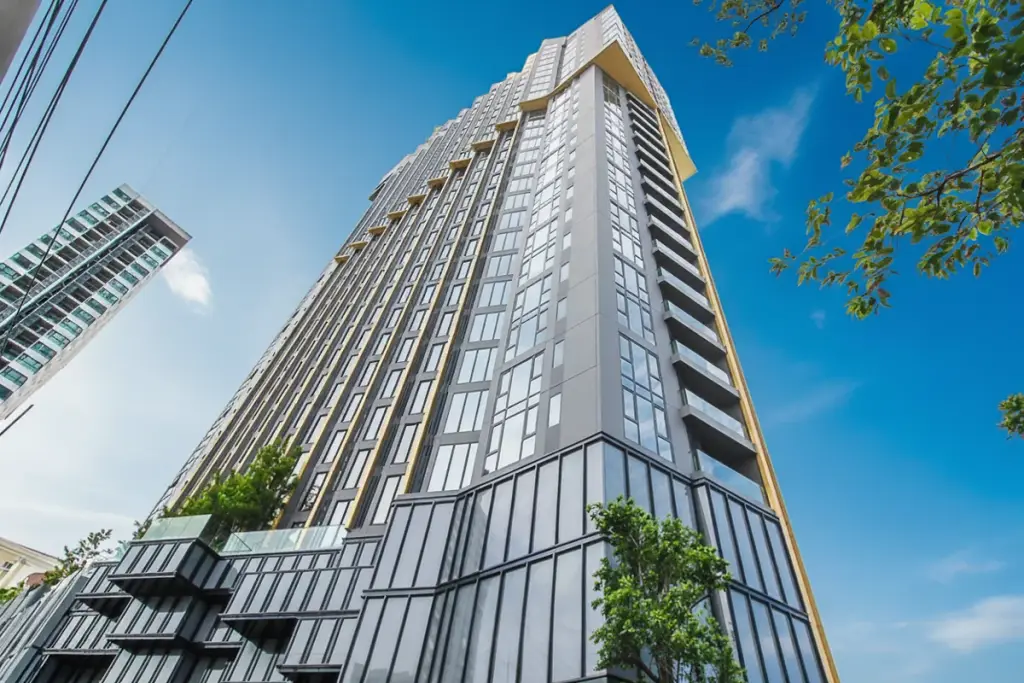 EDGE Central Pattaya: Tall, modern high-rise building with glass and dark gray facade against a bright sky.