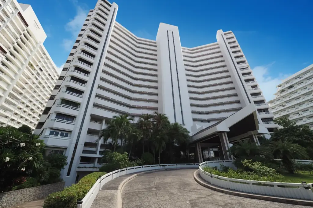 Grand Condotel main building exterior with curved driveway and lush tropical landscaping.