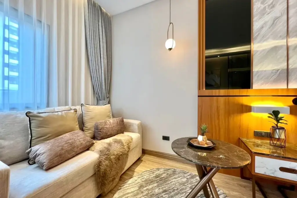 Studio Condo for Sale at Wyndham Jomtien Pattaya cozy sitting area with beige sofa and marble side table