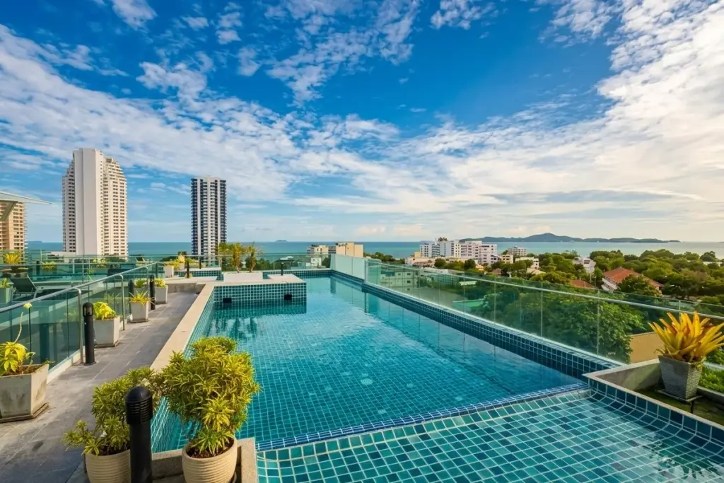 Laguna Bay 1 rooftop terrace with lounge chairs, artificial grass, potted plants, and city/ocean views.