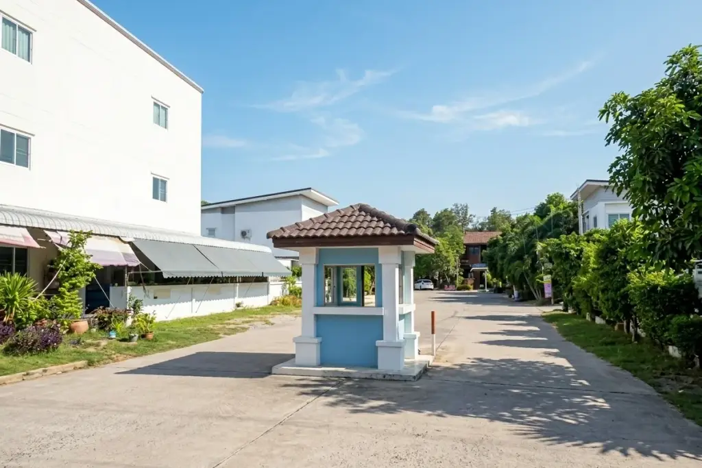 Saen Charoen Orchid Park street view with a large white house, red gate, and a pickup truck parked on the road.