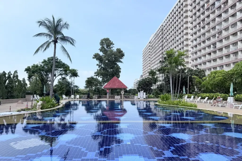 Rimhad Jomtien Condominium S2 outdoor pool with red-roof gazebo, palm trees and high-rise tower