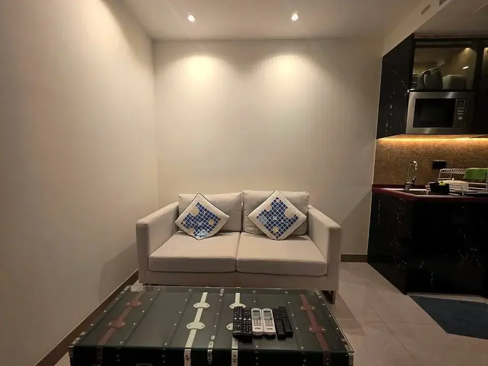 1 Bedroom Condo for Rent at Riviera Ocean Drive living room with beige loveseat and trunk coffee table
