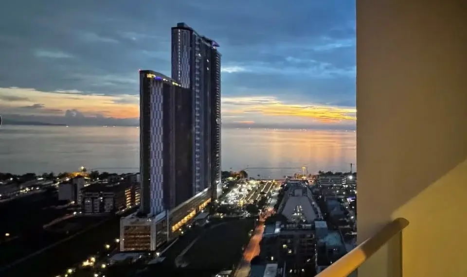 1 Bedroom Condo for Sale at Riviera Ocean Drive balcony view of twin towers and coastline at sunset