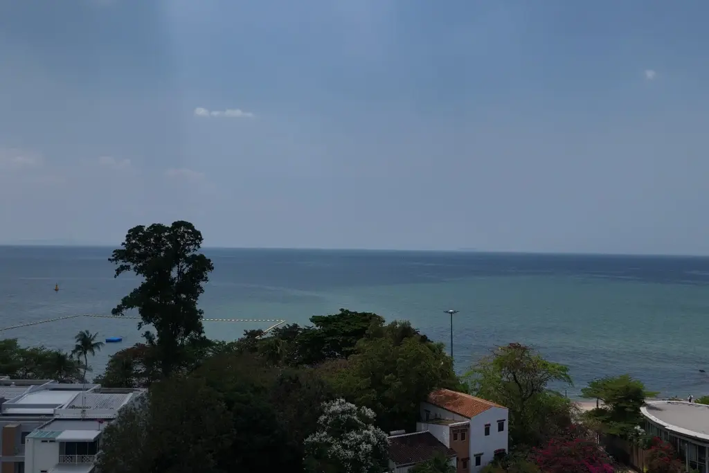1 Bedroom Condo for Sale at Sea Sky By Sand panoramic sea view with tropical trees and coastal homes in Pattaya