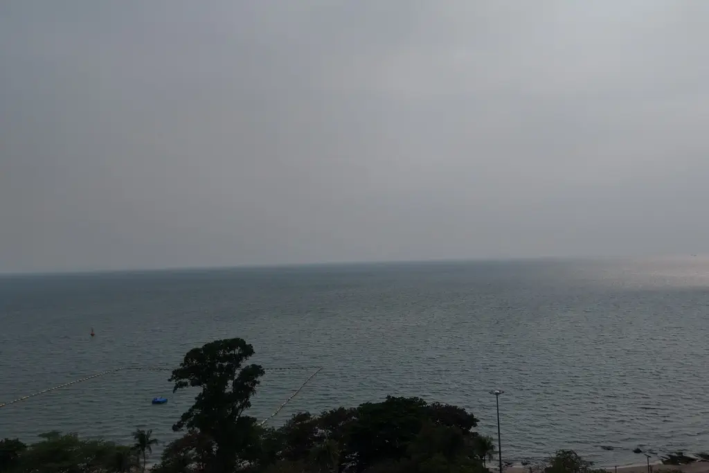 1 Bedroom Condo for Sale at Sea Sky By Sand overcast sea view with palm trees and swim buoy line from balcony