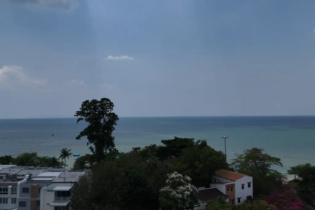 1 Bedroom Condo for Sale at Sea Sky By Sand ocean view from balcony with tropical trees and coastal buildings