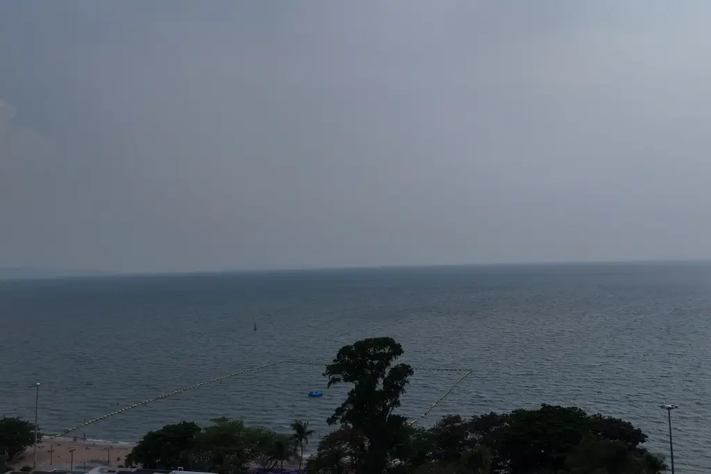 1 Bedroom Condo for Sale at Sea Sky By Sand sea view with roped swimming area and beachfront trees at dusk