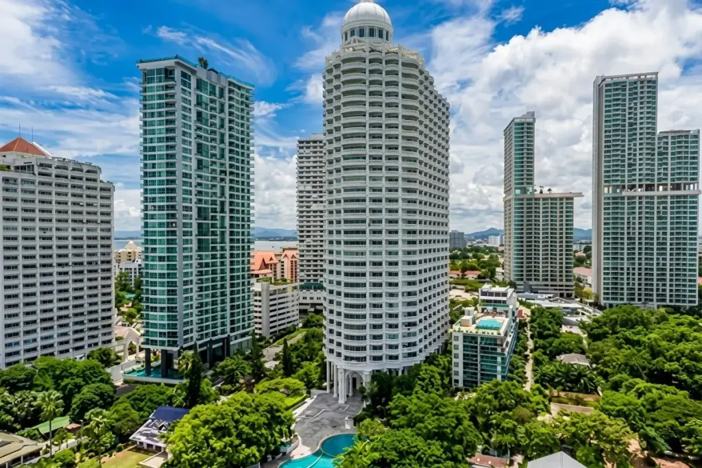 Park Beach Condominium large outdoor swimming pool with a building and lush trees in the background