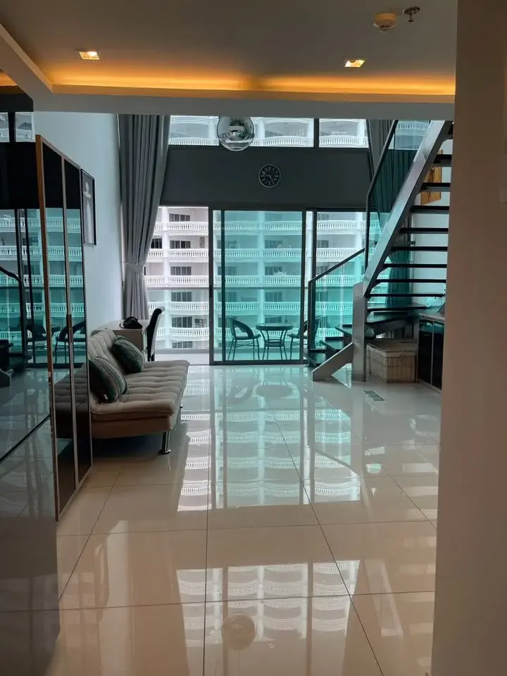 1 Bedroom Condo for Sale at Wongamat Tower living room with duplex staircase and balcony view