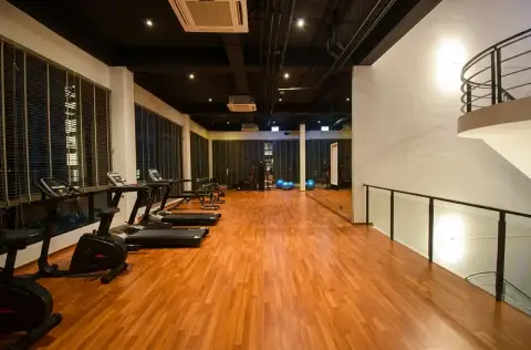 Dormy Residences Sriracha fitness center with treadmills and wooden flooring on upper level