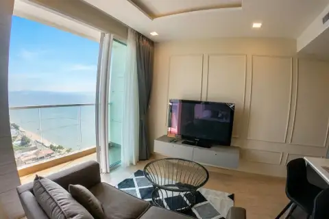 1 Bedroom Condo for Sale at Cetus Beachfront living room with sofa, flat-screen TV, and floor-to-ceiling sea view window