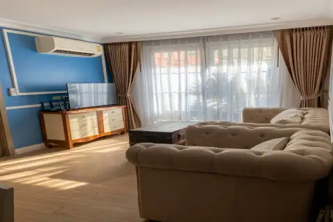 2 Bedroom Condo for Sale at Seven Seas Cote d'Azur living area with blue accent wall and wall-mounted TV