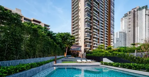 Baan Plai Haad tall condo building exterior with a modern swimming pool and lush landscaping.
