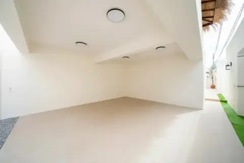 4 Bedroom House for Sale at The Sunshine House spacious empty covered car park with white walls, smooth floor and ceiling spotlights