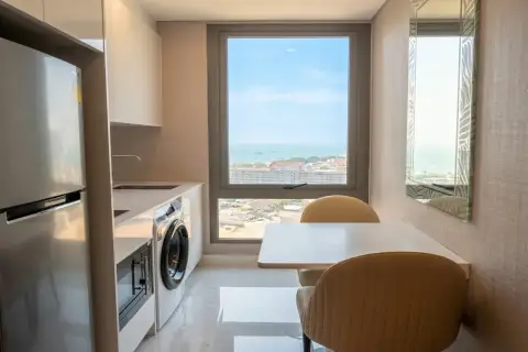 1 Bedroom Condo for Rent at Copacabana Beach Jomtien compact kitchen with fridge washing machine and dining table with sea view