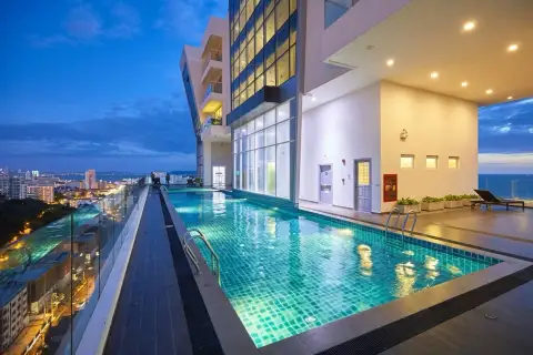The Vision: Rooftop swimming pool at night, with city lights in the background and a dark blue sky.
