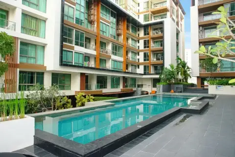 The Urban Pattaya outdoor pool with tiled deck and wooden-accented condo building facade