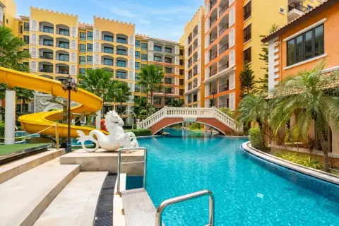 Venetian Signature Condo Resort swimming pool with yellow water slide and horse statue near footbridge