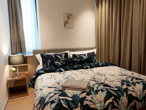 2 Bedroom Condo for Sale at EDGE Central Pattaya bedroom with floral bedding and bedside lamp