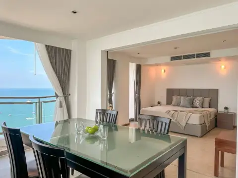 2 Bedroom Condo for Sale at Northshore Pattaya dining table with glass top overlooking balcony and bedroom with sea view