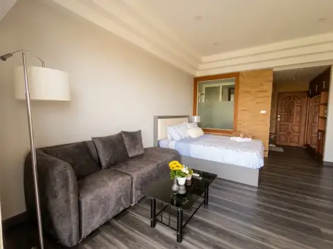 Studio Condo for Sale at Jomtien Condotel & Village open-plan living area with bed, sofa, and dining table