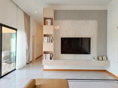 4 Bedroom House for Sale in Huai Yai living area with mounted TV, marble wall panel and built-in shelving