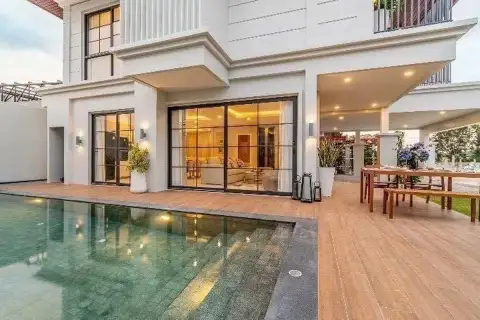 3 Bedroom House for Sale in Huai Yai poolside wood deck with outdoor dining area and glass-fronted living room