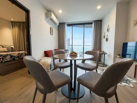 2 Bedroom Condo for Sale at EDGE Central Pattaya dining area with sea view through floor-to-ceiling windows