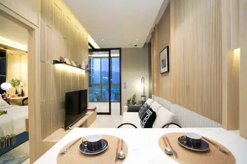 3 Bedroom Condo for Sale at SKYPARK Lucean Jomtien Pattaya living room with sofa, TV, and city skyline view through window