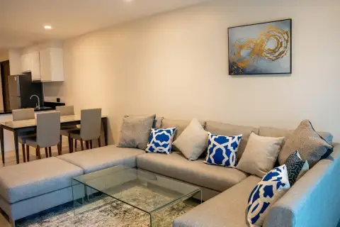 2 Bedroom Condo for Sale at The Elegance open-plan living room with L-shaped sofa, glass coffee table and dining area