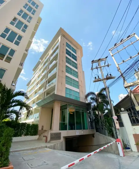 Sunset Boulevard Residence 1 exterior high-rise facade with entrance driveway and parking barrier