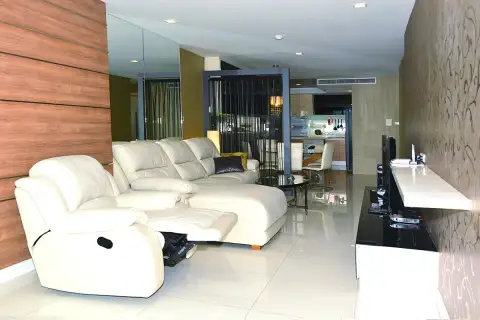 3 Bedroom Condo for Sale at Apus open-plan living room with white leather recliner sofa and dining area