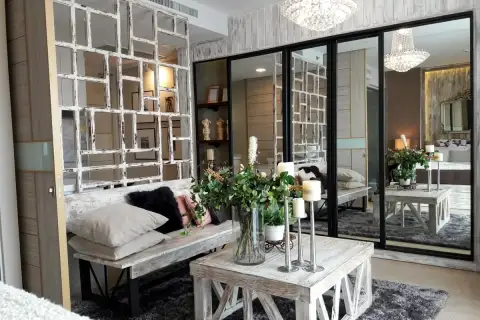 1 Bedroom Condo for Sale at Cetus Beachfront living area with whitewashed bench, mirrored wall panels and crystal chandelier
