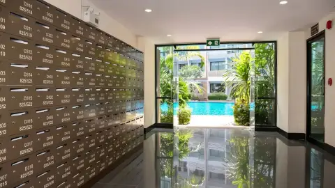 Dusit Grand Park 1 mailroom with lockers and glass entrance overlooking swimming pool