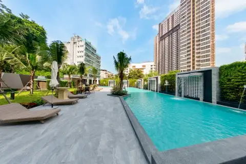Arcadia Center Suite poolside deck with loungers, umbrellas, and city skyline backdrop