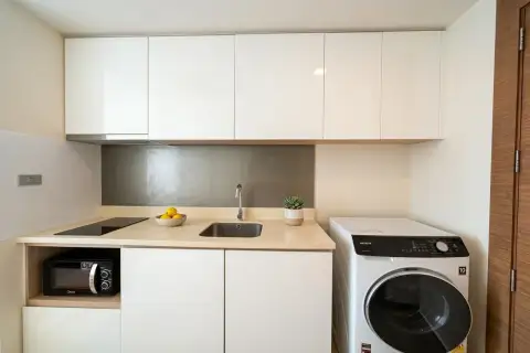 Studio Condo for Sale at Palm Wongamat compact kitchenette with stovetop, sink and washing machine