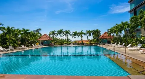 View Talay 6 resort-style swimming pool surrounded by palm trees and gazebos