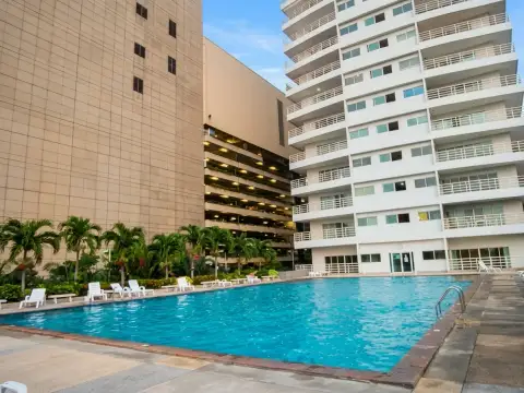 View Talay 6 outdoor pool area with swimmers beside the condo tower and parking garage