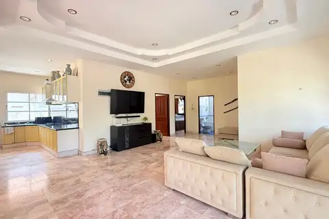 3 Bedroom House for Sale at Mike Orchid Villas 2, spacious living room with sofa, TV, and view of the kitchen.